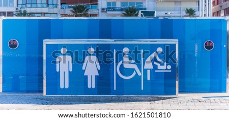 Public toilet station. Blue prefabricated toilet in a public square. Row of toilets.