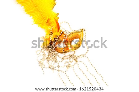 Golden Carnival mask on white background with silver beads. Mardi Gras concept. Copy space, close-up