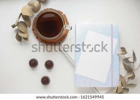 coffee cup and smartphone mockup. eucalyptus and chocolate candies. phone mock up with hearts. notebooks. planner