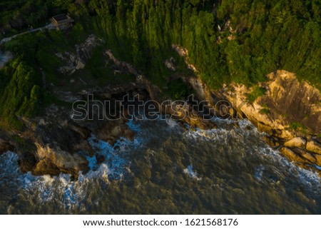 Aerial photograph The tourist attraction in Thailand is the sunset viewpoint, which is a viewpoint by the cliffs. With beautiful sea and abundant forest.The aerial view of the ocean waves and the wond