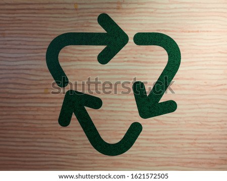 Recycling symbol on a brown wooden table