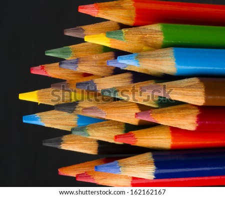 a set of color pencils sharpened and ready for use art supplies artist tools black background