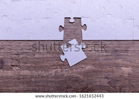 Jigsaw puzzle pieces lying on old wooden rustic boards. Conceptual of innovation, solution finding and integration.