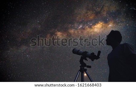 Astronomer with a telescope watching at the stars and Moon. Royalty-Free Stock Photo #1621668403