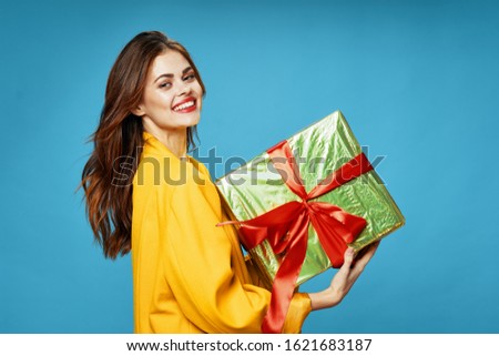 Gift box woman in a yellow sweater on a blue background
