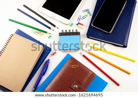 Notepad with place for text. Note on the desktop with stationery. Pencils, notebooks, phone, pen. Training, study, workflow - preparing a plan and important notes.