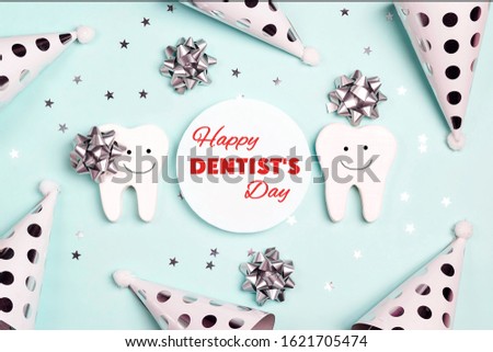 Happy Dentist's Day greeting card with teeth and holiday caps on a blue background.