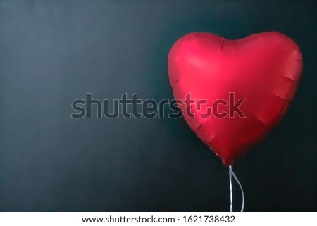 Red air balloons in the shape of a heart on a black background. valentines day, love. Place for text