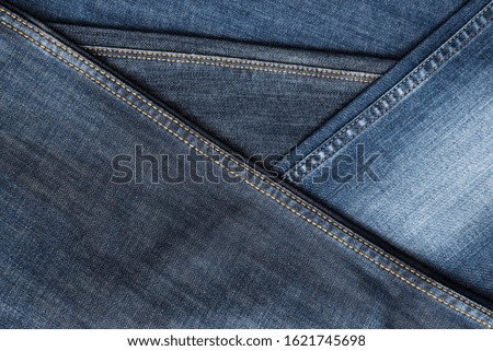 Denim background. Blue jeans seams of different shades and textures. Copy space.