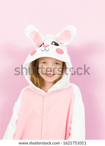pretty blonde girl with cozy rabbit costume is posing in the studio