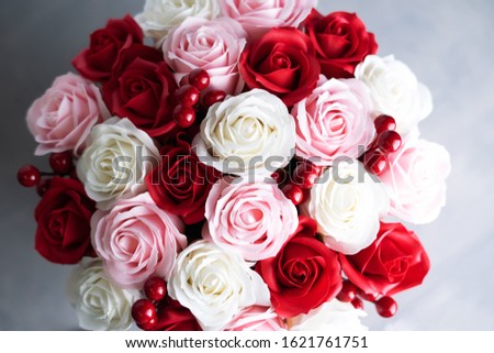 Flowers in bloom: Bouquet of red and white roses on a gray background.