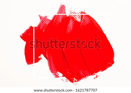 The texture of red lipstick on a white background, close-up.