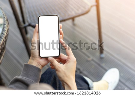 Mockup image blank white screen cell phone.woman hand holding texting using mobile on desk at coffee shop.background empty space for advertise text.people contact marketing business,technology 