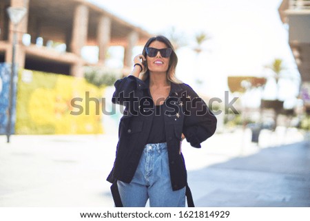 Young beautiful woman wearing sunglasses smiling happy and confident. Standing and walking at town street