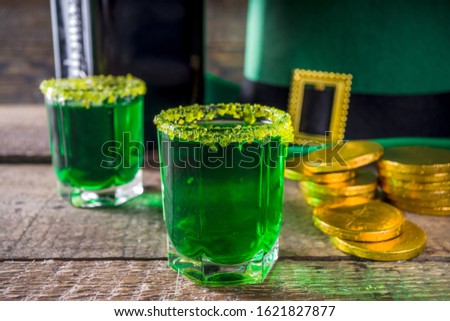 Drinks for St. Patrick's Day party. Good luck leprechaun shot cocktail. Green strong drink in a shot glass with gold decor. Royalty-Free Stock Photo #1621827877