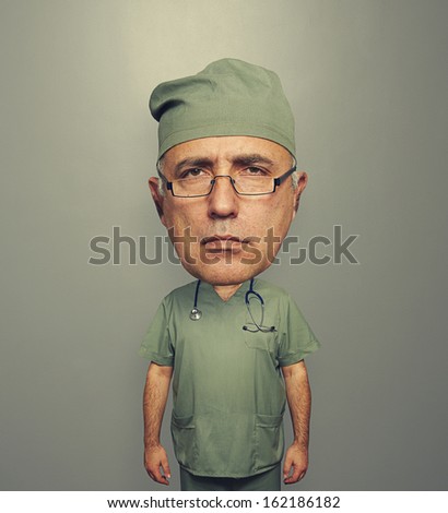 serious bighead doctor in glasses and uniform over grey background