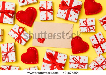 Top view of colorful valentine background made of craft envelope, gift boxes and red textile hearts. Valentine's Day concept.