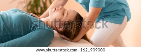 Female physiotherapist or a chiropractor adjusting patients neck. Physiotherapy, rehabilitation concept. Cropped shot banner. Royalty-Free Stock Photo #1621909000