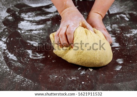 Woman kneading dough with hans for making homemade bread.