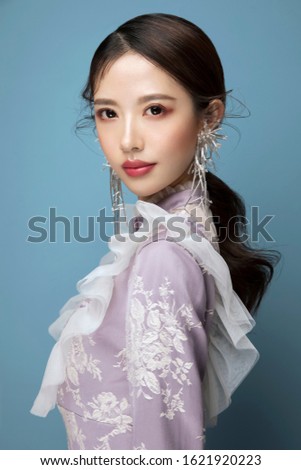 Gorgeous Asian girl taking photos in studio