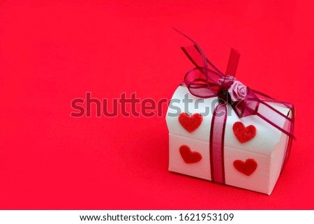 Beautiful gift box decoration with blurred red hearts over blurry red background used for your design, for lover romantic symbol. Holiday and valentine's day concept.