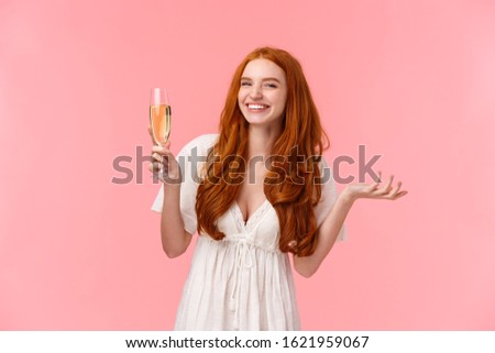 Lovely charismatic bride feeling happy and joyful, celebrating best day her lfie, looking camera amused, smiling raising glass champagne, drinking and partying, standing pink background