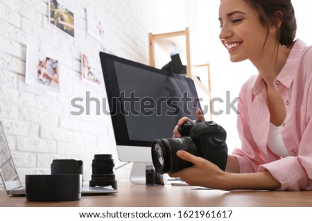 Professional photographer with camera working at table in office