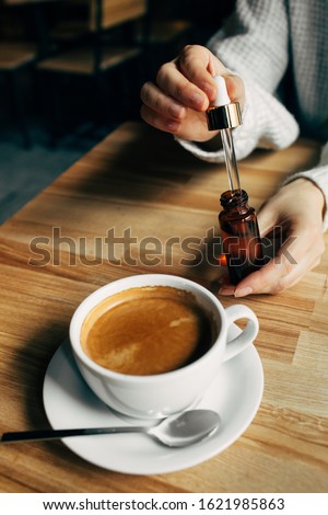 Adding CBD oil in a coffee cup Royalty-Free Stock Photo #1621985863