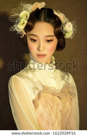 Beautiful young asian woman in white dress in yellow background