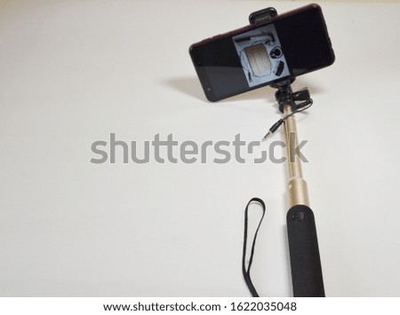 A set for a blogger. On a white background smartphone and selfie stick for photo and video.