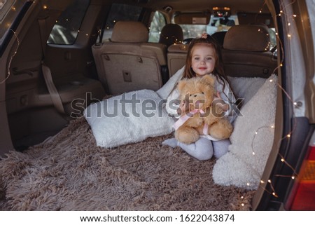 A series about the journey of a happy family. Little cute girl enjoys the warm autumn weather in the forest in car travel
