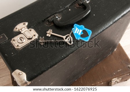 rustic leather vintage suitcases and old two keys with sign home sweet home. welcome home