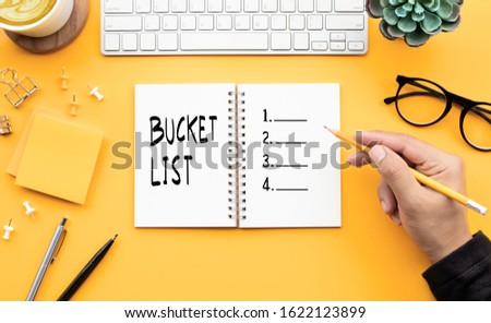Youngman writing bucket list on notepad.Goal-plan-action and resolution concepts ideas