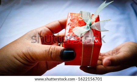 The hand's child gave a red gift box from hand's parent with copy space white background close up view, happy birthday concept, Happy Chinese new year idea, image