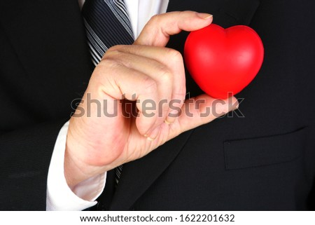 Valentines Day. A man holds a Valentine's Day Heart. Isolated on white. Room for text. Clipping Path. Hearts represent love world wide. Valentine's Day is when people give each other gifts of love. 