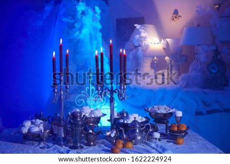 Table setting with candles, marshmallows and tangerines. Holidays, catering and hospitality concept.