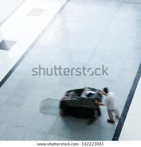 People cleaning floor with machine. blur motion