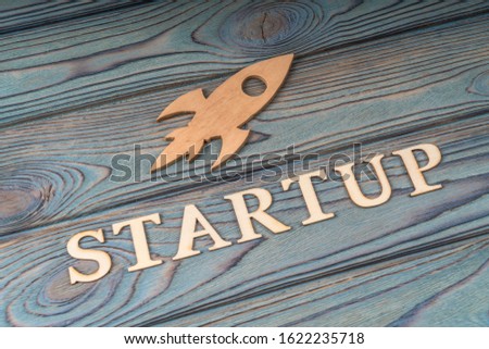 Rocket startup on a wooden background. Business idea, success and achievement, take off. Concept for new experience, start project