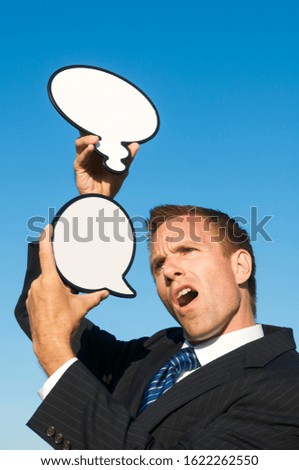 Confused businessman giving out mixed messages holding blank speech and thought bubbles