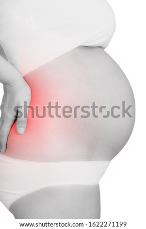 Black and white photo of unrecognizable caucasian pregnant woman with backache pain. Close up view of woman with back pain. Isolated on white. Place of pain tinted red.