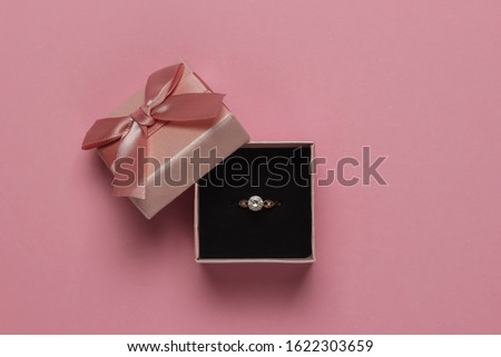 Gift box and engagement gold ring with diamond on pink pastel background. Wedding, romantic concept. Jewelry. Top view. Flat lay Royalty-Free Stock Photo #1622303659