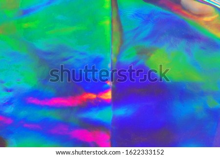 Photo texture of a fashionable holographic film. Abstract colorful holographic futuristic texture.