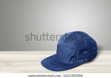 Blue baseball cap on wooden desk