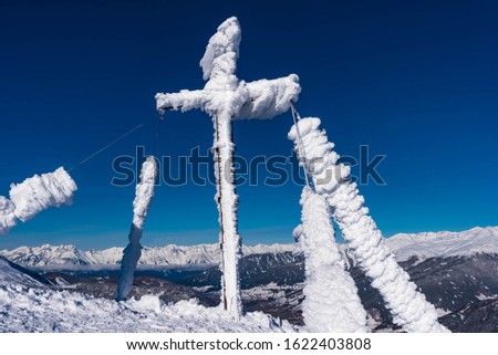 snowy cross on the summit of the mount noesslachjoch in tyrol