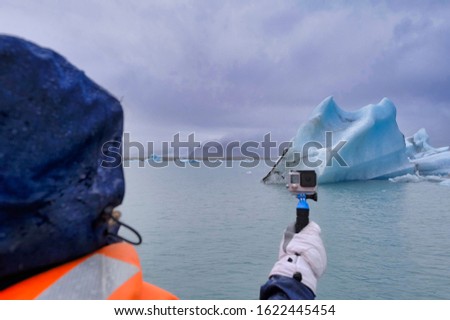 Young woman films Jokulsarlon glacier lake in Iceland