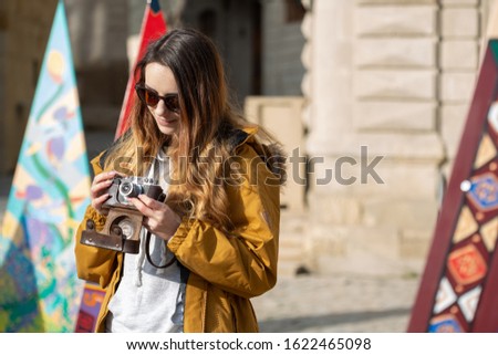 Photo of young tourist girl exploring streets of Baku. Moody photos of teenager girl visiting old city and taking photos of the city.