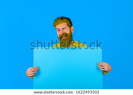 Winking bearded man holds advertising board. Seasons sale. Discount. Black friday. Advertising and sale. Online shopping. Advertising banner. Barber fashion and beauty marketing. Copy space for text.