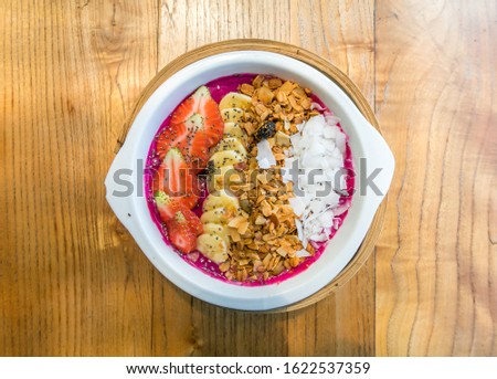 Fitness Acai, dragon fruit and Papaya Smoothie Bowl with strawberries, banana, granola and coconut flakes. Top view