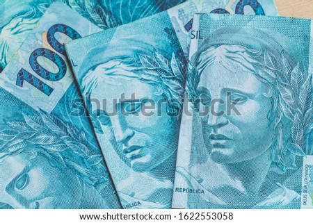 Brazilian Real - BRL. One hundred reais banknotes with focus on the Real symbol.
