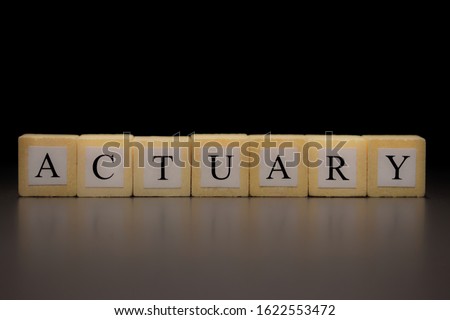 The word ACTUARY written on wooden cubes isolated on a black background Royalty-Free Stock Photo #1622553472